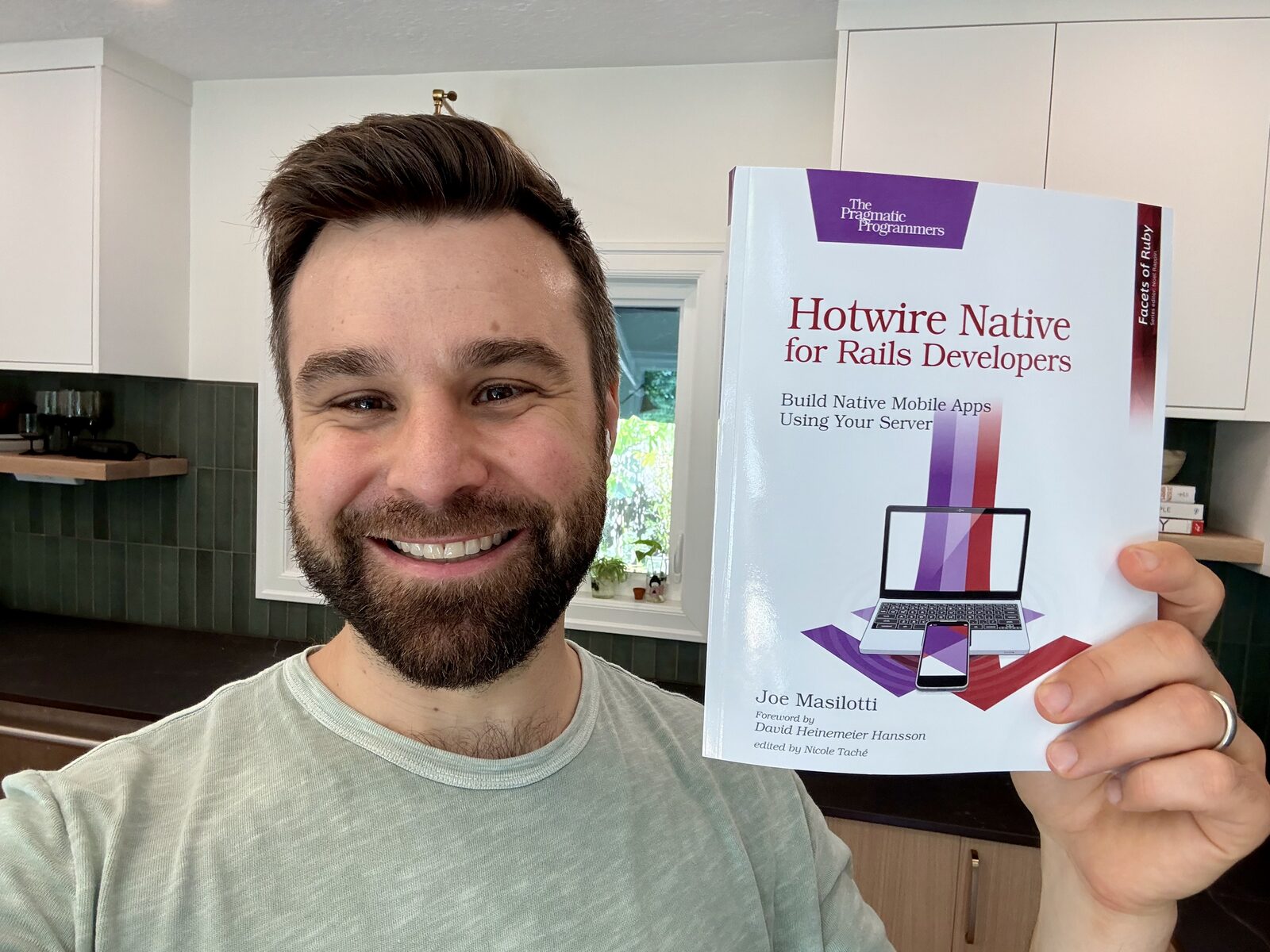 Joe Masilotti holding a print copy of Hotwire Native for Rails Developers